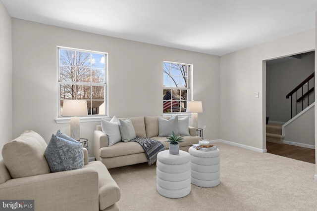 living room with carpet floors, stairs, and baseboards