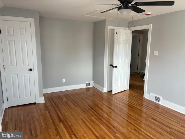 unfurnished bedroom with wood finished floors, visible vents, and baseboards