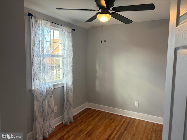 unfurnished room with baseboards and wood finished floors