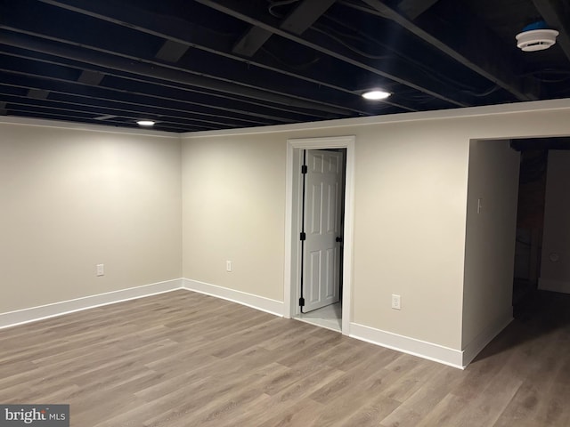 finished below grade area featuring wood finished floors and baseboards