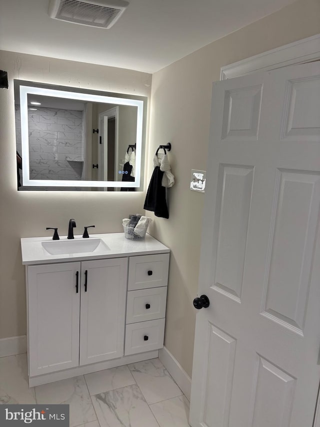 bathroom with marble finish floor, baseboards, visible vents, and vanity