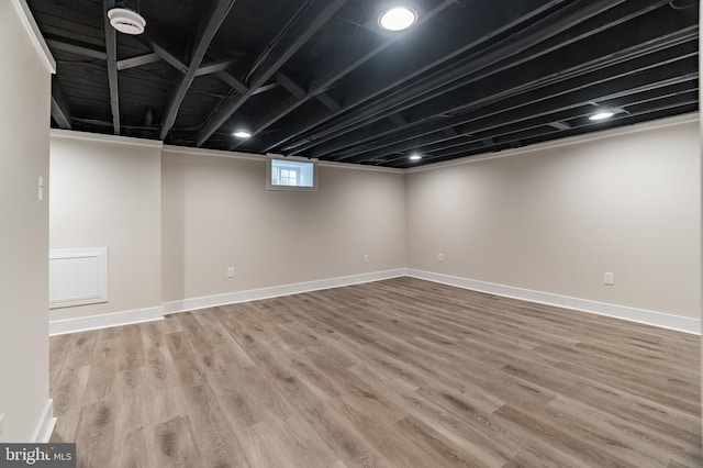 basement with light wood-style flooring and baseboards