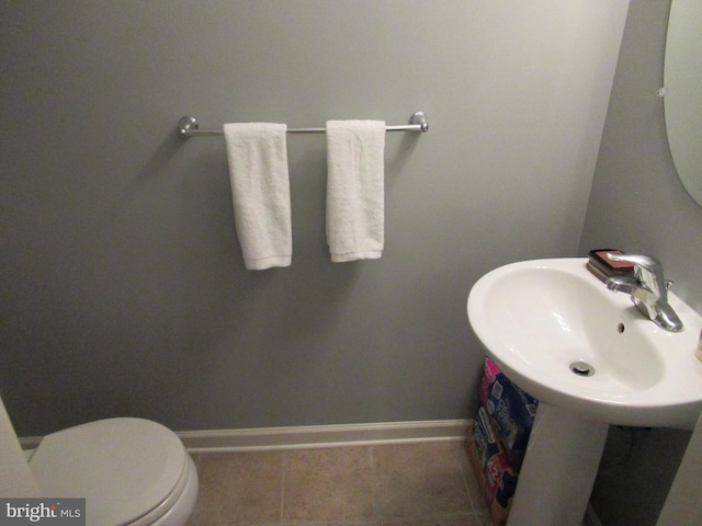 bathroom with toilet, a sink, baseboards, and tile patterned floors