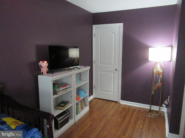 bedroom featuring baseboards and wood finished floors