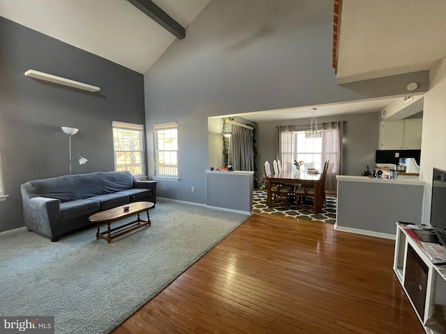 living room featuring high vaulted ceiling, hardwood / wood-style floors, baseboards, and beam ceiling