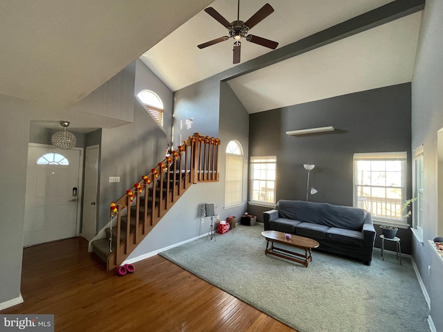 living room featuring ceiling fan, high vaulted ceiling, wood finished floors, baseboards, and stairs