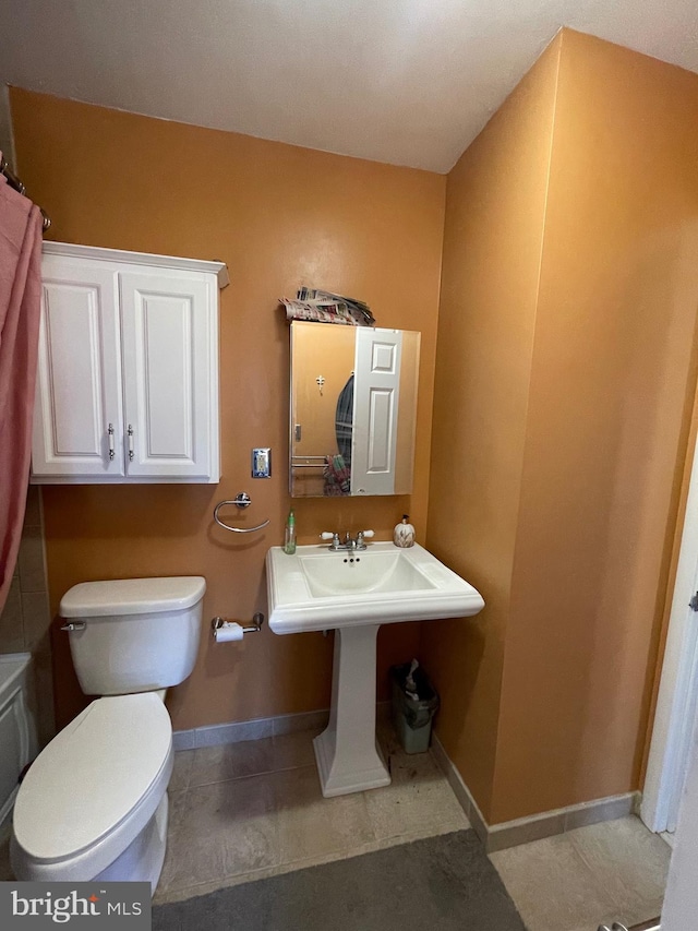 bathroom featuring toilet and baseboards