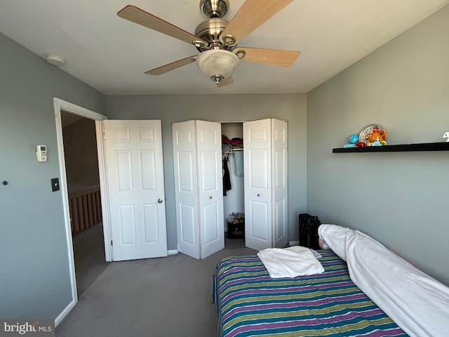 carpeted bedroom with ceiling fan, a closet, and baseboards