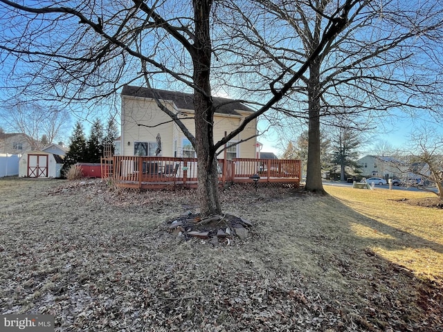 view of yard featuring a deck, a shed, and an outdoor structure