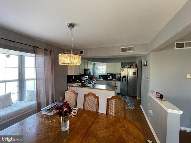 dining space featuring dark wood-style floors, baseboards, and visible vents