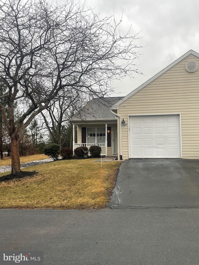 view of front facade with covered porch, driveway, a front yard, and a garage