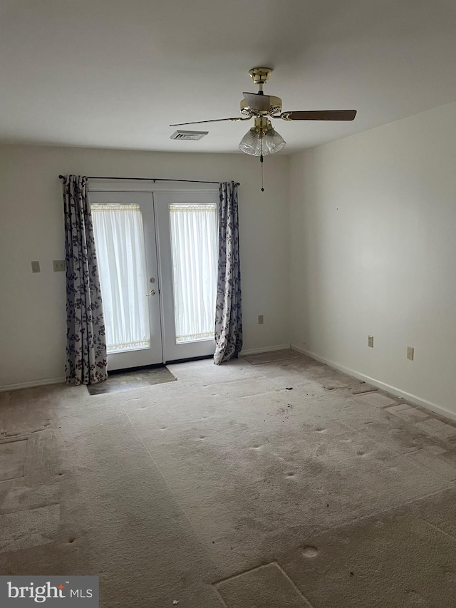 empty room featuring visible vents, carpet floors, baseboards, and french doors