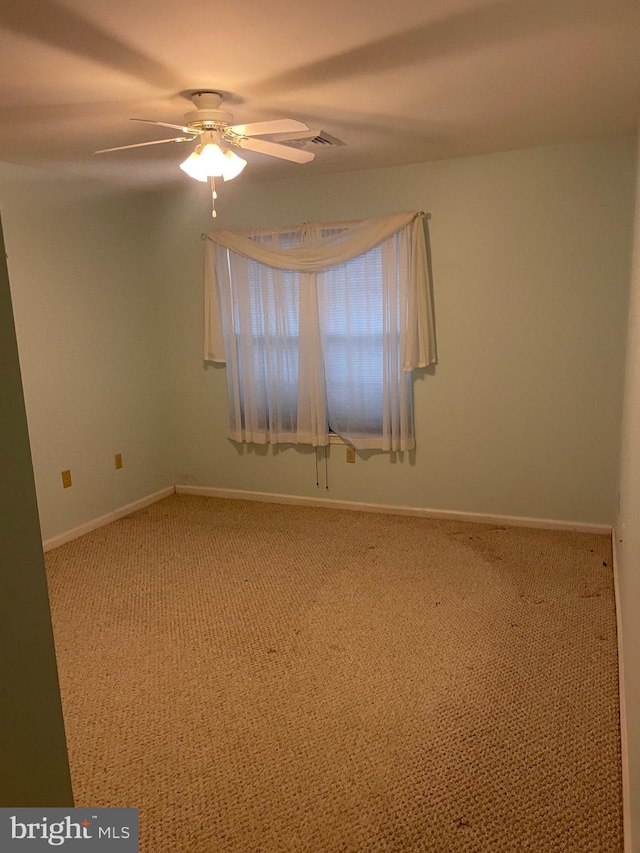 unfurnished room with visible vents, a ceiling fan, baseboards, and carpet floors