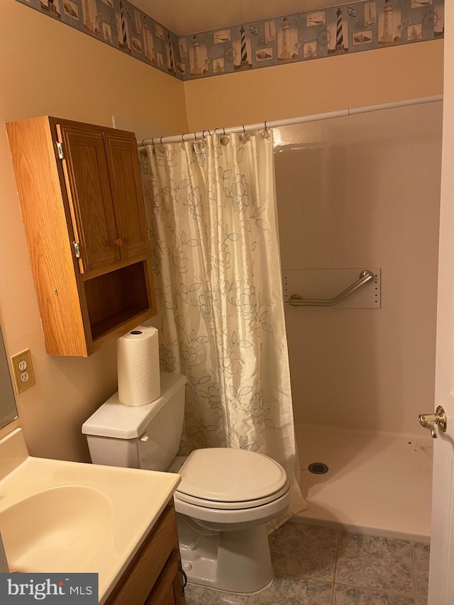 full bath with tile patterned flooring, a stall shower, toilet, and vanity