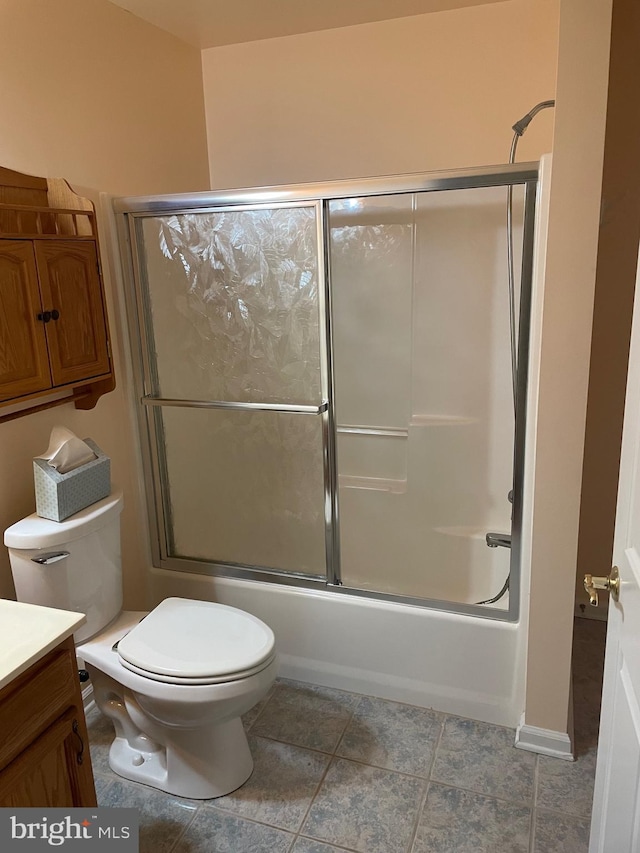 bathroom featuring toilet, vanity, and shower / bath combination with glass door