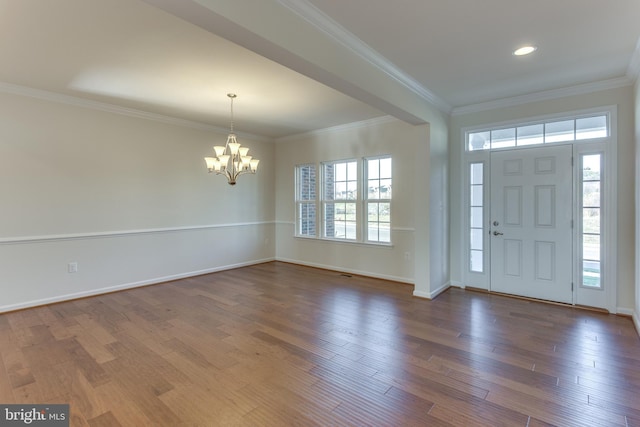 entryway with dark wood-style floors, baseboards, ornamental molding, and an inviting chandelier