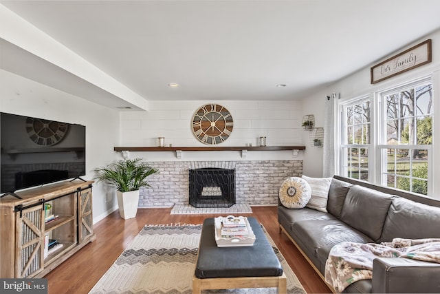 living area with recessed lighting, baseboards, wood finished floors, and a fireplace