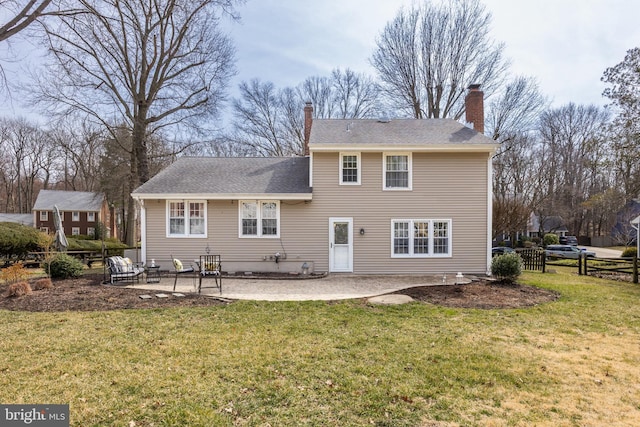 back of property featuring a yard, a chimney, a patio, and fence