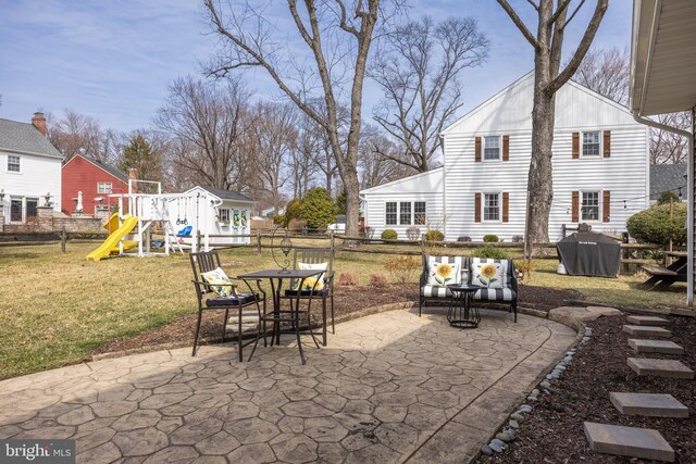 view of patio with fence, a grill, and a playground