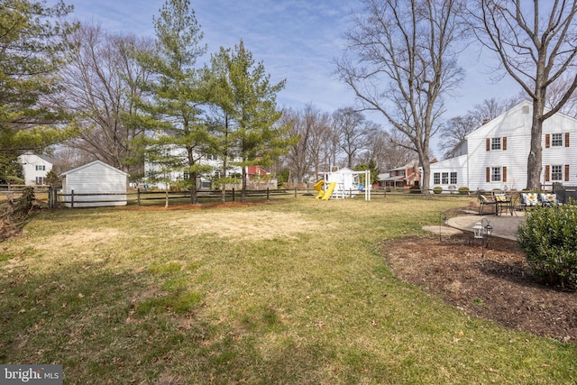 view of yard with a patio, a playground, and a fenced backyard