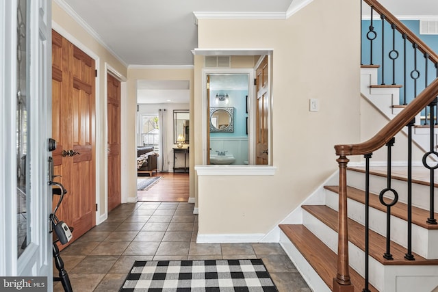 entrance foyer with stairway, visible vents, crown molding, and baseboards