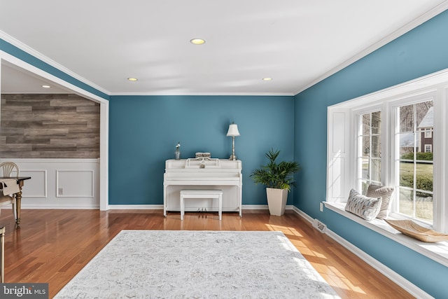 sitting room featuring recessed lighting, a wainscoted wall, wood finished floors, and ornamental molding