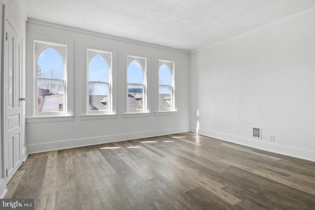 spare room with a healthy amount of sunlight, baseboards, and wood finished floors