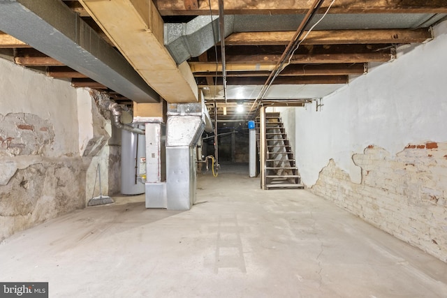 unfinished basement featuring water heater, heating unit, and stairs