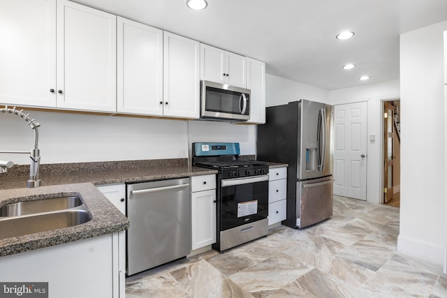 kitchen with appliances with stainless steel finishes, a sink, white cabinetry, and recessed lighting