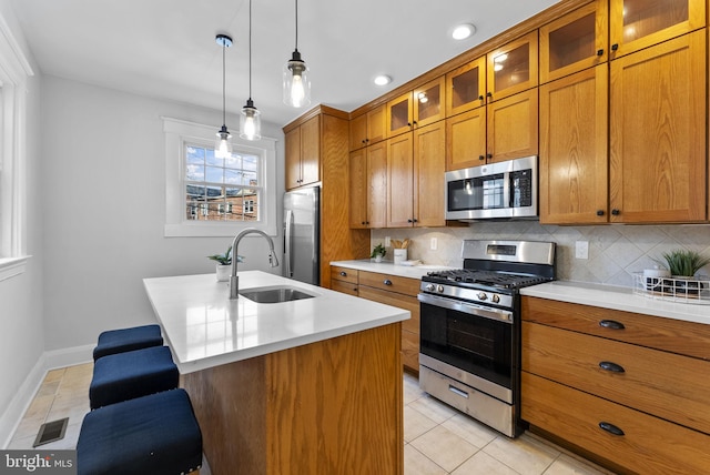 kitchen with a sink, brown cabinetry, visible vents, and stainless steel appliances