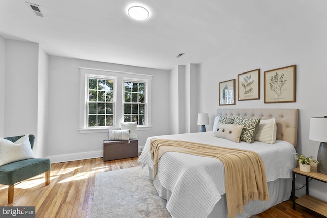 bedroom featuring visible vents, wood finished floors, and baseboards