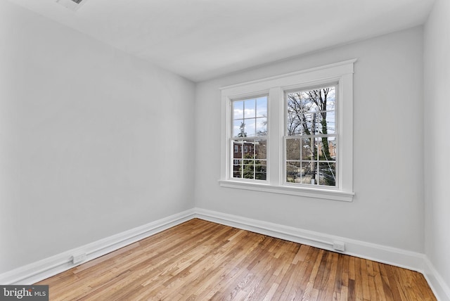 empty room with light wood-type flooring and baseboards