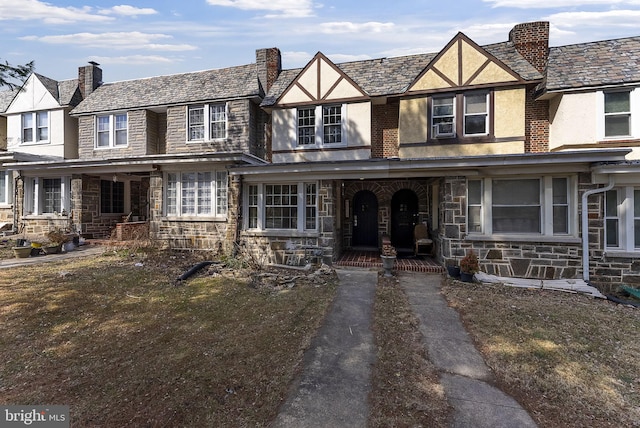 view of front of property featuring stucco siding, stone siding, and a porch