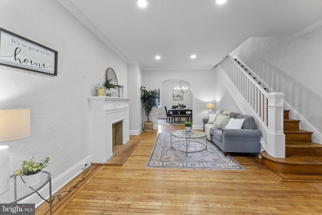 living room featuring wood finished floors, baseboards, recessed lighting, ornamental molding, and stairs