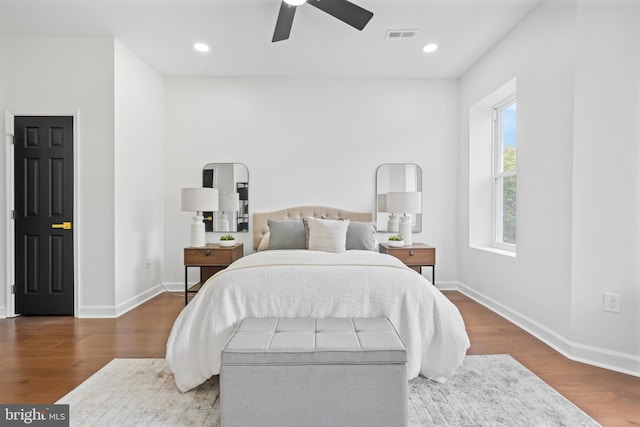 bedroom with baseboards, wood finished floors, and recessed lighting