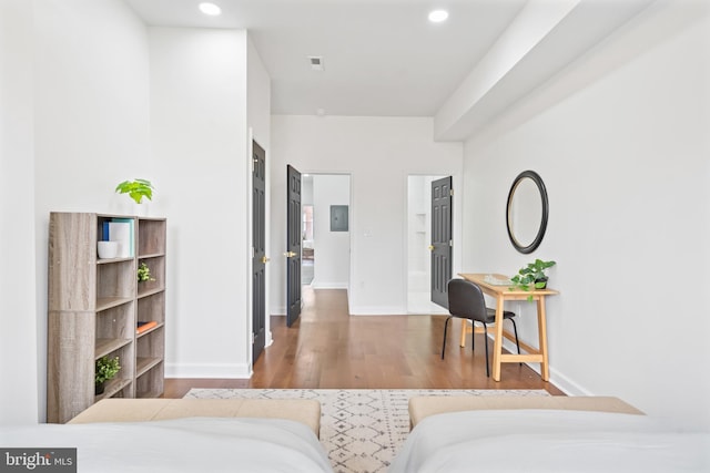 bedroom featuring baseboards, wood finished floors, and recessed lighting