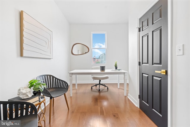 office space featuring baseboards and light wood finished floors