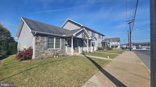 view of front of home with a shingled roof, stone siding, and a front lawn