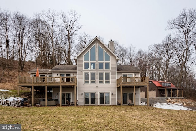 rear view of property with an outdoor structure, a lawn, a wooden deck, a chimney, and a hot tub