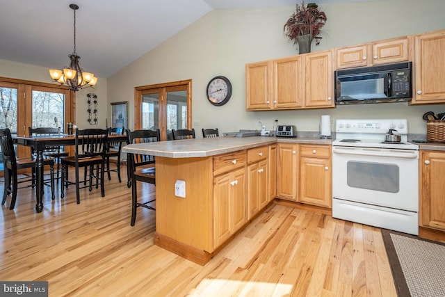 kitchen with a peninsula, light wood-type flooring, a kitchen bar, black microwave, and white range with electric cooktop