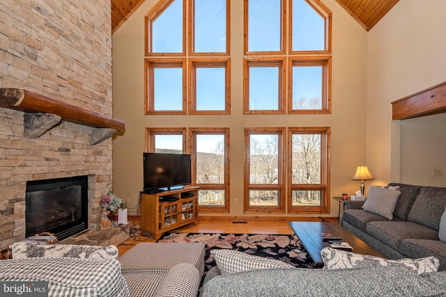 living room with high vaulted ceiling, a fireplace, wood finished floors, and wooden ceiling