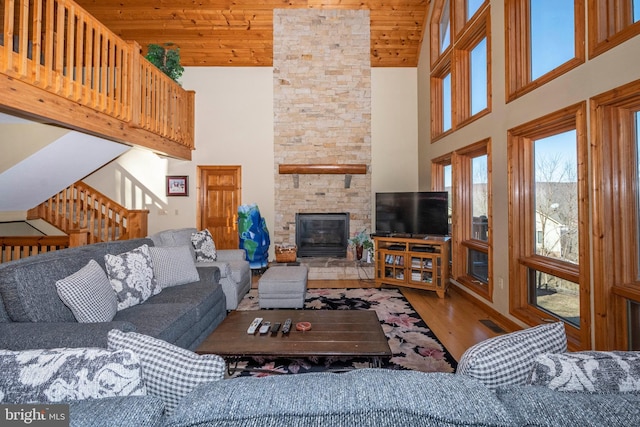 living room with high vaulted ceiling, wood ceiling, a fireplace, and wood finished floors