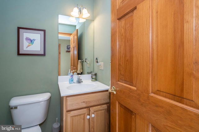 half bathroom featuring vanity and toilet