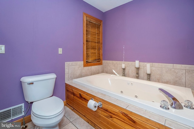 bathroom with visible vents, baseboards, toilet, a tub with jets, and tile patterned floors