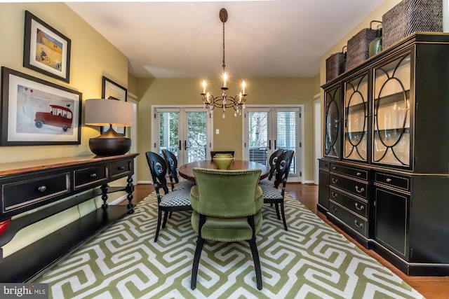 dining space featuring an inviting chandelier, dark wood-style floors, and baseboards