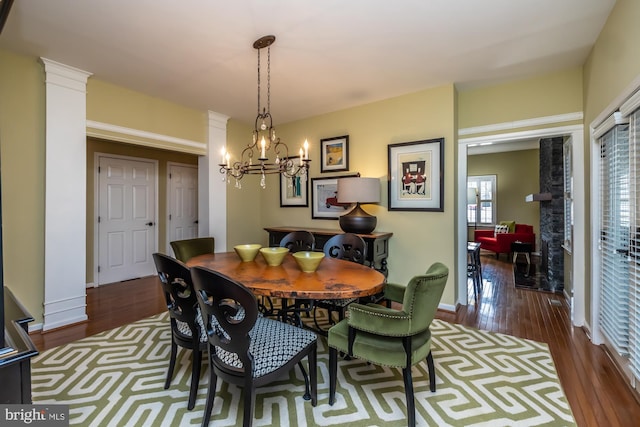 dining space with a chandelier, baseboards, and wood finished floors