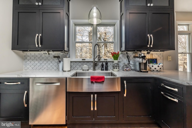 kitchen with a sink, decorative backsplash, light stone countertops, and dishwasher