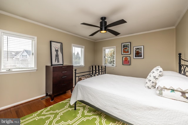 bedroom with a ceiling fan, crown molding, baseboards, and wood finished floors