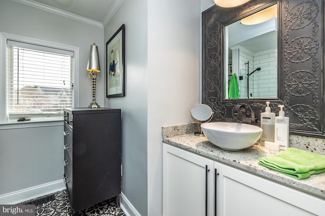 bathroom with a shower, baseboards, vanity, and crown molding