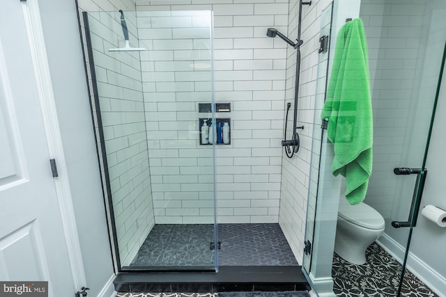 full bath with a shower stall, toilet, and baseboards